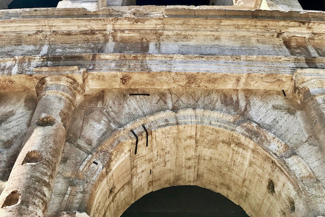 closeup of rome colosseum entrance closeup of original number over entrance to rome colosseum