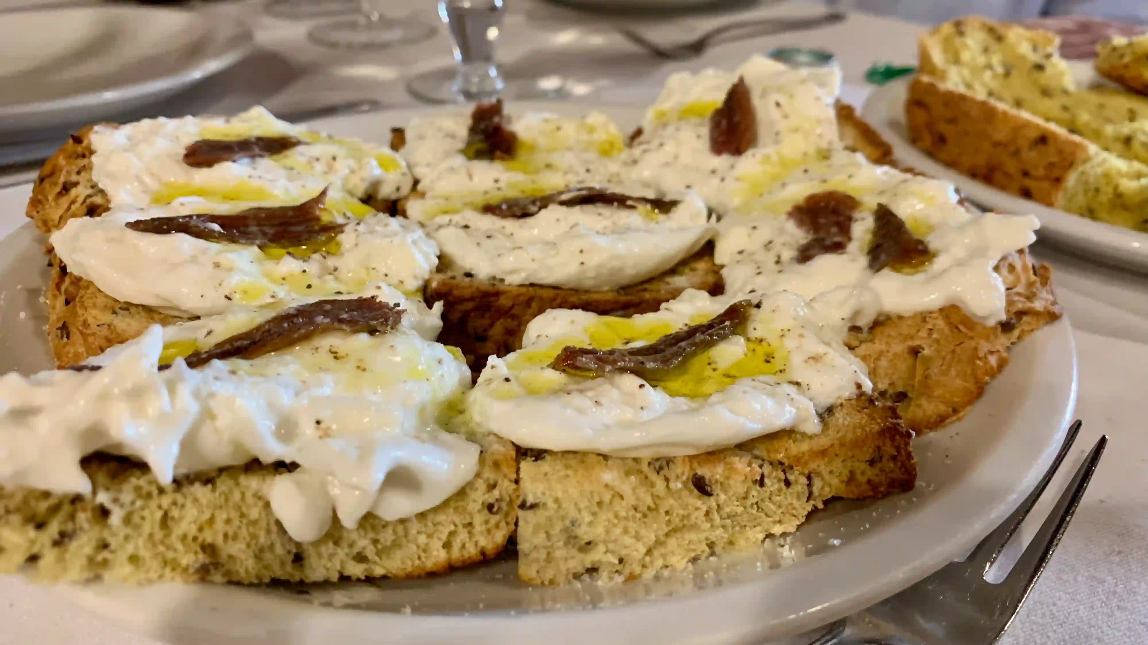 appetiser of bruschetta with burrata cheese and anchovies hostaria farnese - burrata alici