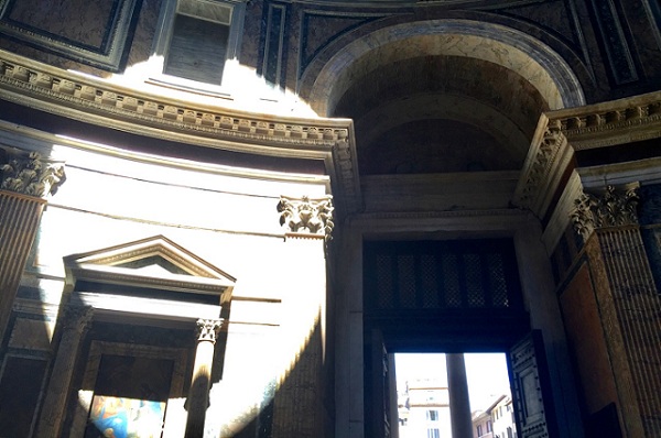 light from oculus moving towards door of pantheon