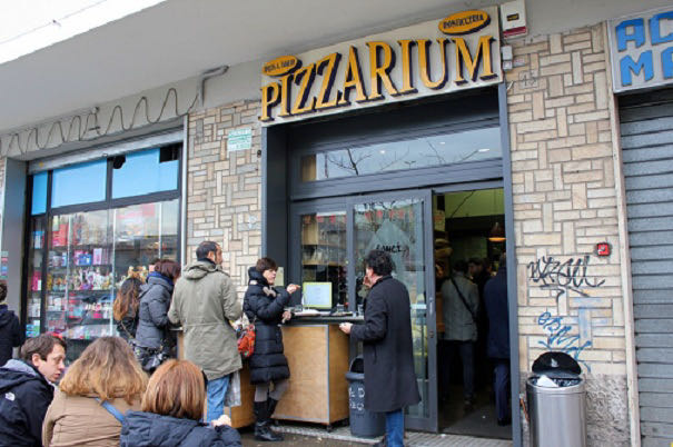 standing outside pizzarium to eat pizza by the slice
