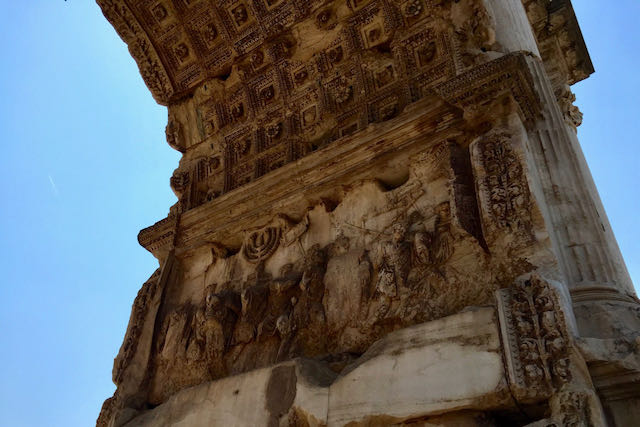 Closeup of the Arch of Titus showing the Romans returning after destroying the Temple in Jerusalem. arch of titus depicting romans bringing back spoils of war from judea