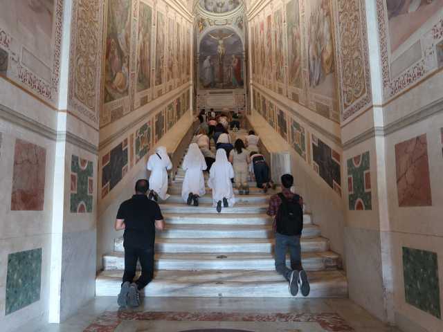 people praying on uncovered marble steps of scala sancta people praying on uncovered marble steps of scala sancta