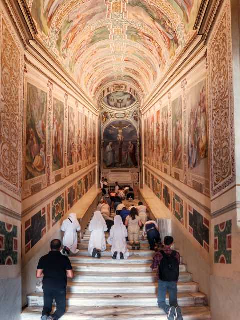 people praying on uncovered marble steps of scala sancta