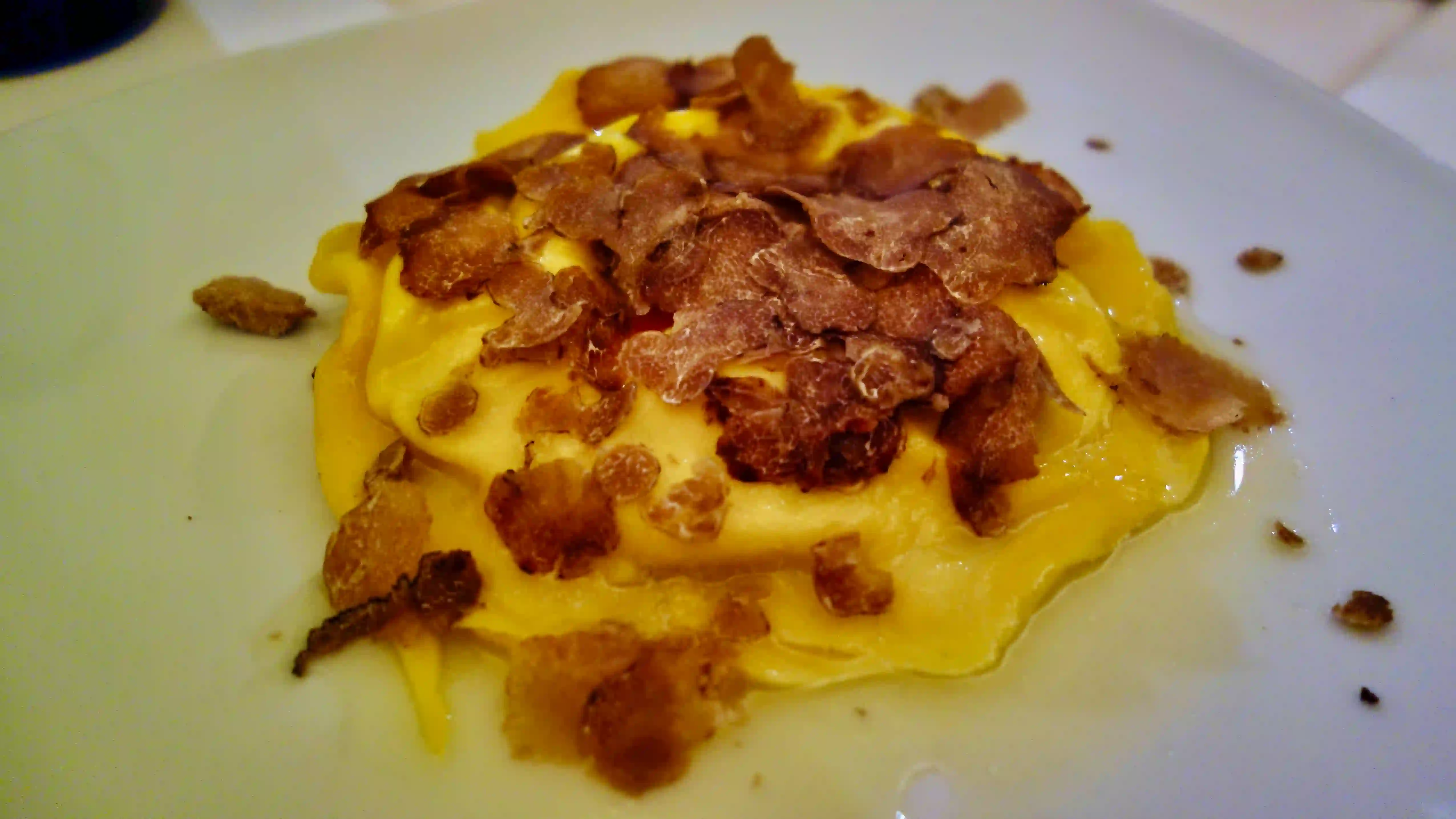 Tortello filled with herb ricotta and egg yolk, topped with black truffles trattoria monti tortello with truffles